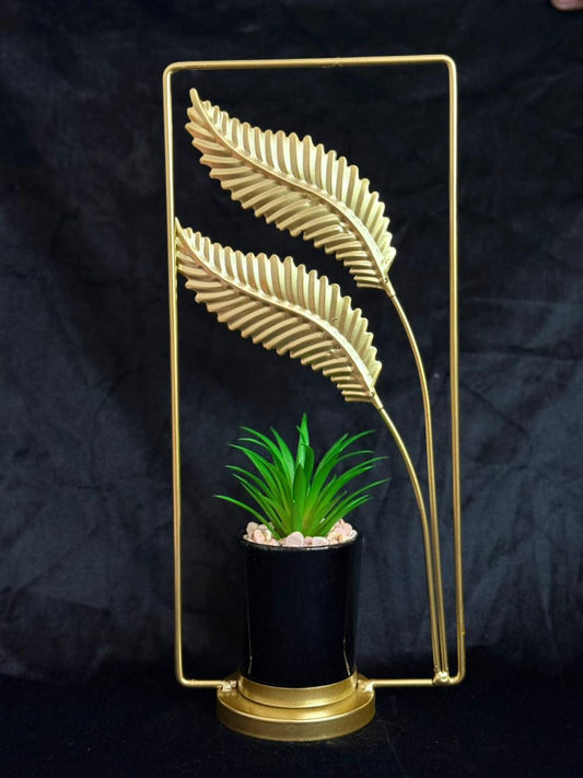 Decorative plant holder with gold leaf design on a dark background