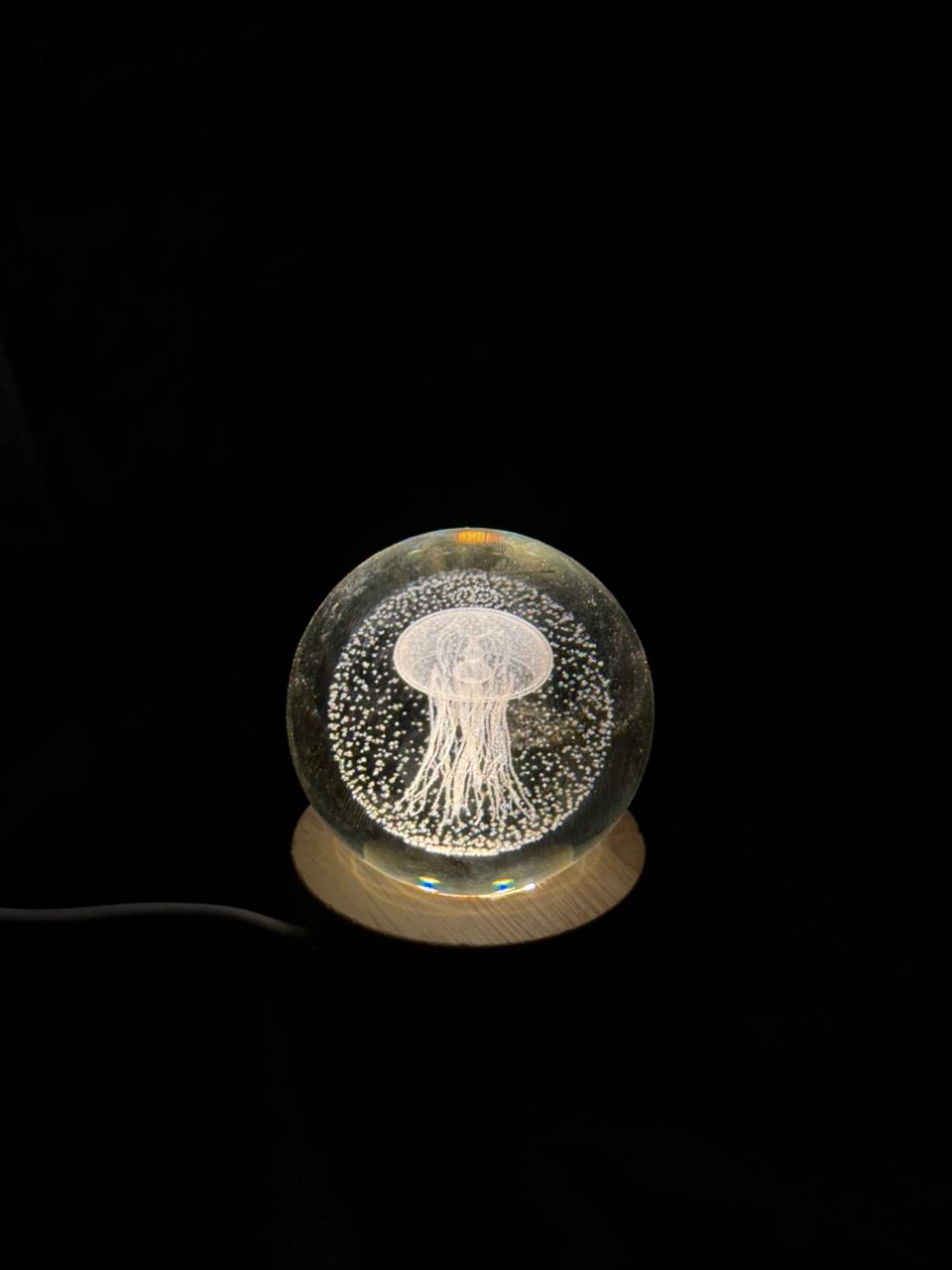 Glass orb with jellyfish design on a black background